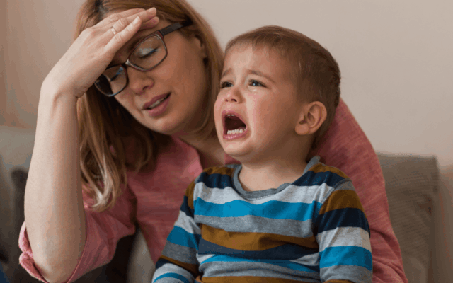 Médico alerta que esta reação moldará o desenvolvimento dos bebês: Uma mulher estressada e uma criança chorando.