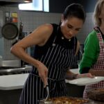 Meghan serve comida para mulheres em serviço comunitário