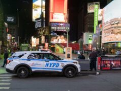 Menina de 6 meses encontrada abandonada na Times Square: NYPD Um carro da polícia de Nova York estacionado à noite na Times Square, na cidade de Nova York, cercado por grandes outdoors e anúncios bem iluminados.