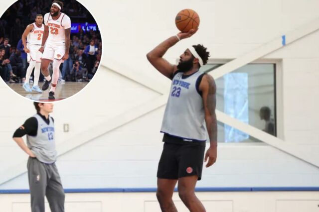 Mitchell Robinson nº 23 do New York Knicks pratica lances livres, vestindo uma camisa cinza e shorts pretos.