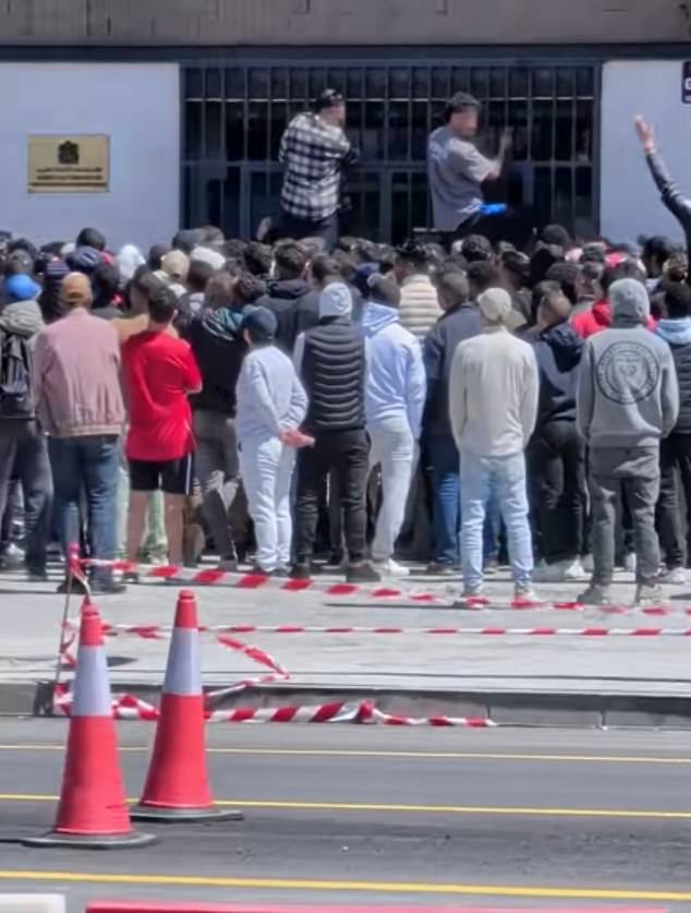 Milhares de migrantes chegam aos consulados em toda a Espanha As imagens capturaram migrantes escalando os portões de segurança enquanto tentavam entrar nos consulados na Espanha