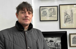 ‘Minha coleção da cidade ficou tão grande que abri um museu’ Uma parede de exposição mostrando pinturas e gravuras emolduradas representando Coventry, bem como sinalização antiga.