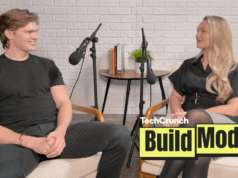 Não pare de contratar humanos – pare de contratar os humanos errados, diz o fundador da Artisan Artisan CEO, Jaspar Carmichael-Jack and Build Mode host Isabelle Johannessen sit facing each other in a podcast studio with microphones, mid-conversation, in front of a white brick wall; a small table with books and a plant sits between them, and a “TechCrunch Build Mode” logo overlay appears in the lower right corner.