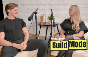 Não pare de contratar humanos – pare de contratar os humanos errados, diz o fundador da Artisan Artisan CEO, Jaspar Carmichael-Jack and Build Mode host Isabelle Johannessen sit facing each other in a podcast studio with microphones, mid-conversation, in front of a white brick wall; a small table with books and a plant sits between them, and a “TechCrunch Build Mode” logo overlay appears in the lower right corner.
