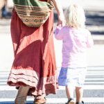 Imagem genérica de mãe e filho atravessando a rua.