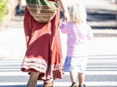 Neste momento, milhares de crianças australianas estão presas em alojamentos institucionais Imagem genérica de mãe e filho atravessando a rua.