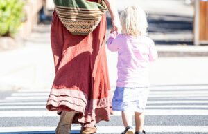 Neste momento, milhares de crianças australianas estão presas em alojamentos institucionais Imagem genérica de mãe e filho atravessando a rua.
