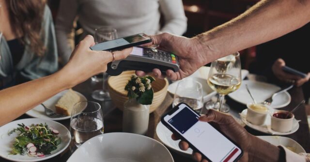 Amigos pagando sem contato no restaurante