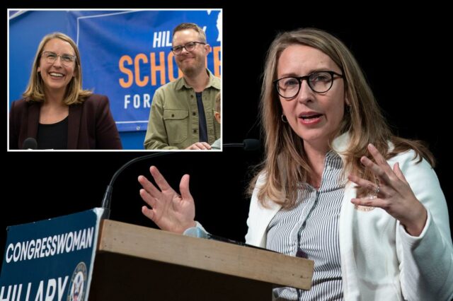 Hillary Scholten e seu marido Jesse Holcomb diante de um banner de campanha.