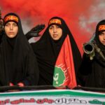 Mulheres portando armas semelhantes a mísseis disparados no ombro andam em um caminhão durante uma manifestação pró-governo no Dia do Exército Nacional, em 17 de abril, em Teerã, Irã.