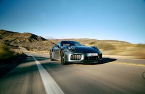 O Porsche 911 Turbo S 2026 comprime o próprio tempo 2026 porsche 911 turbo carro de alto desempenho dirigindo em uma estrada aberta com ângulos dinâmicos