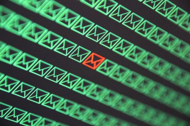 red email envelope in a sea of green email envelopes