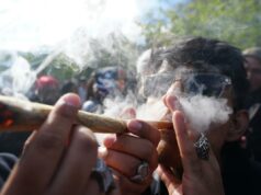 O administrador de Trump reescreve o livro de regras sobre maconha com reclassificação – tornando a pesquisa e os serviços bancários muito mais fáceis Um homem de óculos escuros exala fumaça de um baseado de maconha em uma celebração de cannabis.