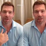 Eric Swalwell com uma camisa de colarinho azul claro falando para a câmera, com a mão direita perto do peito.