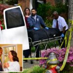 A equipe do escritório do médico legista remove um corpo de uma casa após um aparente assassinato-suicídio.