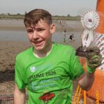 Albert Crates (foto) conseguiu correr, andar e rastejar até a vitória no domingo, através de um trecho de 440 metros do lamacento rio Blackwater, em Essex - tornando-o a pessoa mais jovem a vencer a corrida.