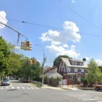 Um entregador uniformizado da Amazon passa por um veículo de entrega da Amazon.