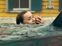 O novo filme Shark da Netflix é o lançamento com menor pontuação em 2026 A woman holding a baby as sharks prowl in the water
