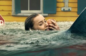 O novo filme Shark da Netflix é o lançamento com menor pontuação em 2026 A woman holding a baby as sharks prowl in the water