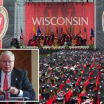 Jay Rothman, presidente do Sistema da Universidade de Wisconsin, vestindo terno e gravata vermelha, está sentado a uma mesa com um microfone e uma lata de Pepsi.