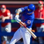 AJ Ewing, do New York Mets, acerta uma bola de beisebol durante o treinamento de primavera.