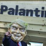 An activist dressed as U.S. President Donald Trump stands in front of a mock Trojan horse