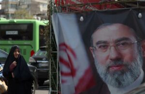 O rosto do líder supremo do Irã, Mojtaba Khamenei, está tão desfigurado que ele precisará de uma cirurgia plástica Duas mulheres iranianas passam por uma faixa representando o novo líder supremo do Irã, o aiatolá Mojtaba Khamenei.