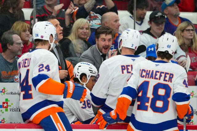 O assistente técnico do New York Islanders, Benoit Desrosiers, conversa com os defensores Scott Mayfield (24), Ryan Pulock (6), Isaiah George (36) e Matthew Schaefer (48) contra o Carolina Hurricanes.