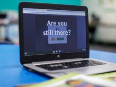 Os aplicativos de IA podem substituir os professores? Especialistas pedem cautela em relação ao modelo escolar Retrato de uma mulher sorridente com longos cabelos escuros, óculos e usando um lenço escuro sobre um suéter rosa.