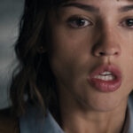 A woman with brown hair stares in shock