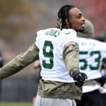 O lado defensivo dos Jets, Will McDonald IV (9), se alonga durante o treino em Florham Park, NJ.