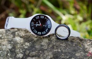Oura Ring 4 vs. Galaxy Watch 8: Por que um anel inteligente supera um smartwatch Wear OS Alguns smartwatches em uma superfície curva com um smartwatch e uma pulseira inteligente ao lado deles.
