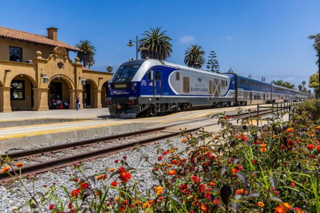 Um trem Pacific Surfliner azul e prata está estacionado na estação ferroviária de Santa Bárbara.