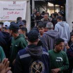 Homens palestinos se reúnem em frente a uma seção eleitoral para participar das eleições locais em Deir al-Balah, no centro da Faixa de Gaza, no sábado.