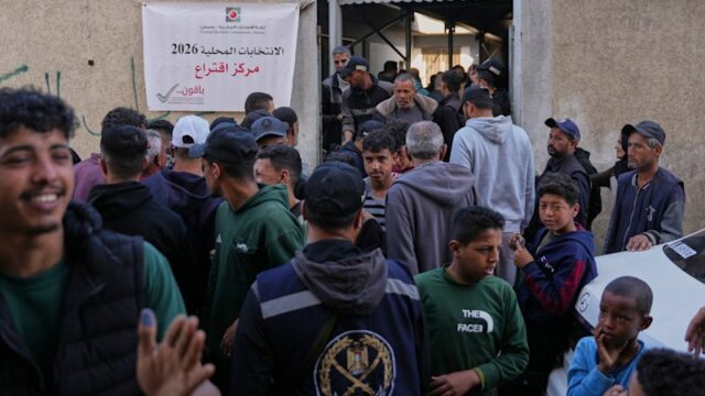 Homens palestinos se reúnem em frente a uma seção eleitoral para participar das eleições locais em Deir al-Balah, no centro da Faixa de Gaza, no sábado.