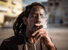 Poderá o bloqueio petrolífero dos EUA apagar o charuto cubano? Um morador de Havana fuma um charuto enquanto pesca no Malecón. (Euan Wallace/Al Jazeera)