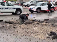 Polícia israelense inspeciona danos na estrada após impacto de míssil Polícia israelense inspeciona danos na estrada após impacto de míssil