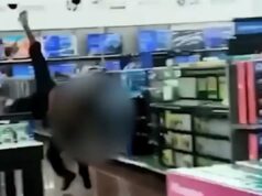 Policial da Geórgia foi afastado após agredir homem no Walmart: ‘Pensei que ele estivesse morto’ Um policial de uniforme escuro fica de costas para a câmera dentro de uma loja, com clientes e mercadorias visíveis ao seu redor.