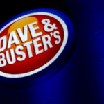 O processo na Carolina do Sul diz que os jogos de Dave & Buster são jogos ilegais. Placa iluminada da vitrine de Dave & Buster à noite com logotipo vermelho e azul no exterior do edifício