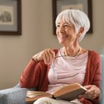 Mãe, bebê e avó brincando com um brinquedo de empilhar.