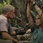 Charlize Theron enquanto Sasha escala um penhasco em