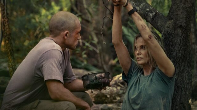 Charlize Theron enquanto Sasha escala um penhasco em 