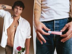 Rob Rausch descobriu esse protetor labial graças à namorada: ‘Quem não quer lábios bonitos?’ Kosas Lip Pulse Glossy Lip Plumper em um tubo rosa claro com fundo texturizado em azul claro, contra uma mancha de brilho labial rosa claro.