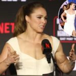 Ronda Rousey falando em entrevista coletiva com o logotipo da Netflix e detalhes do cartão de luta ao fundo.