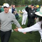 Rory McIlroy dá um tapa na mão de um patrono durante sua rodada de treinos no Masters em 7 de abril de 2026 no Augusta National.