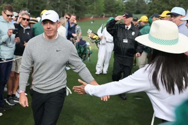 Rory McIlroy dá um tapa na mão de um patrono durante sua rodada de treinos no Masters em 7 de abril de 2026 no Augusta National.