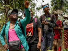 Seis mulheres ganham o prêmio Goldman 2026, o principal prêmio ambiental do mundo Uma jovem com um chapéu largo segura um peixe perto de um rio, sorrindo