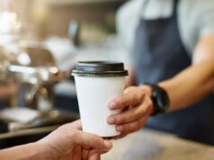 Seu hábito diário de tomar café pode estar remodelando silenciosamente seu intestino e seu humor, segundo estudo Barista entregando uma xícara de café para viagem a um cliente.