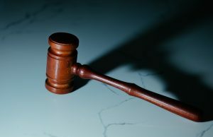 Soldado dos EUA acusado de usar informações confidenciais em esquema de apostas de US$ 400 mil Um martelo de tribunal sobre uma mesa.