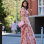 Mandy Bork vista usando óculos escuros marrons da Tom Ford, um vestido longo colorido com botões / plissados ​​/ sem mangas da Emilio Pucci, uma mini bolsa Hermes Kelly rosa claro e sandálias creme brancas da Chanel, durante a Paris Fashion Week - Haute Couture Outono Inverno 2022 2023, em 06 de julho de 2022 em Paris, França.